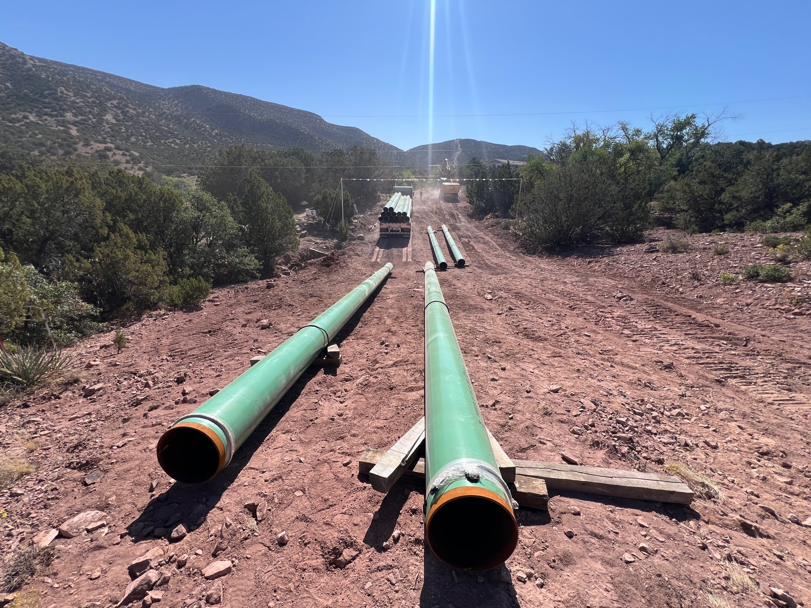 Coated pipeline strings staged on a construction right-of-way